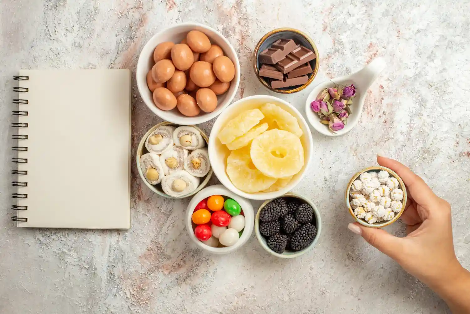 Variety of healthy snacks including nuts, dried fruits, and chocolate on a table