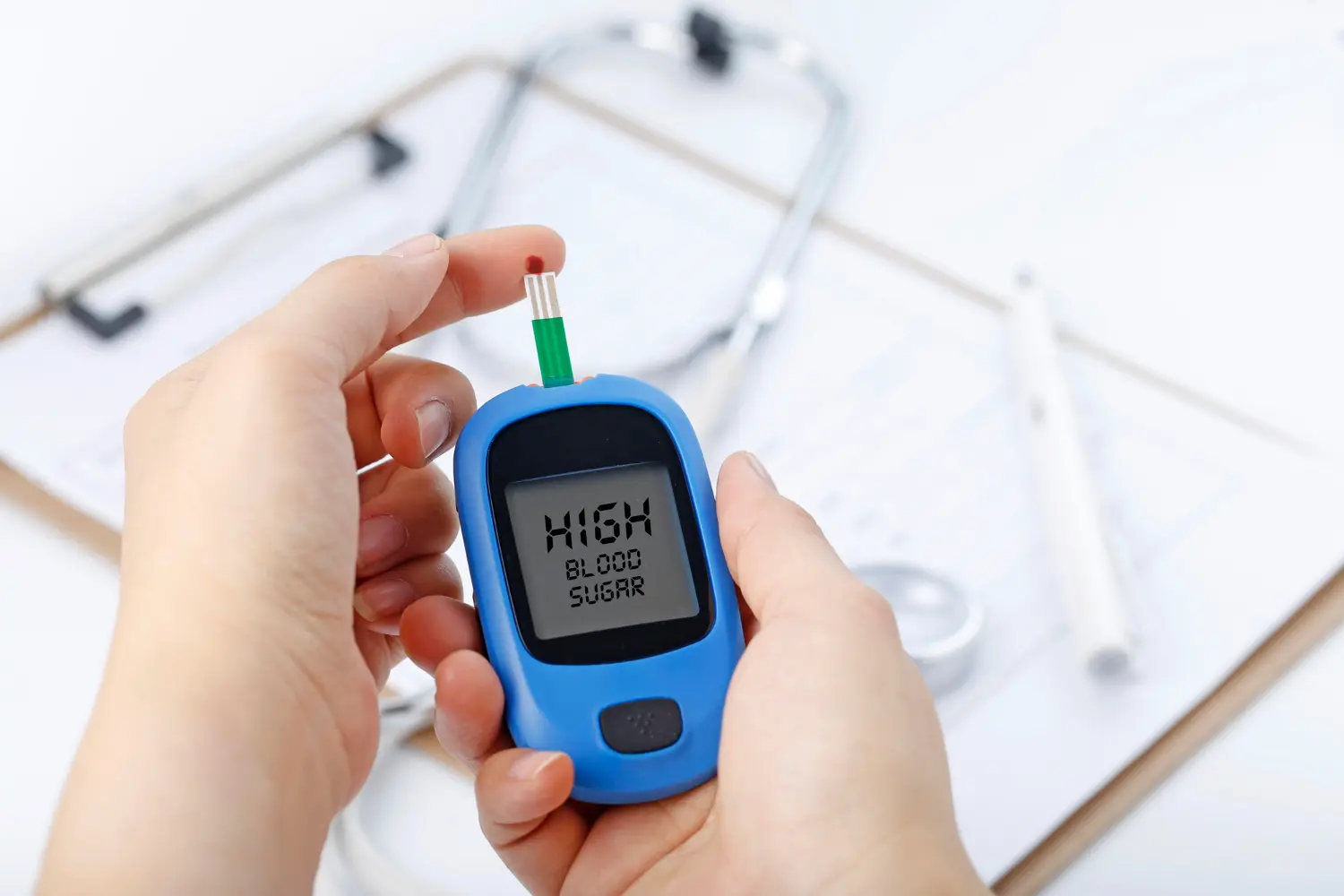 Glucometer showing high blood sugar result held by a person