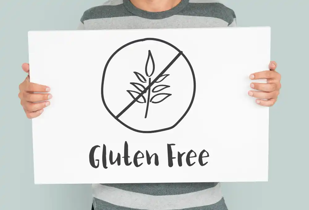 Person holding a Gluten Free sign, representing safe dietary choices
